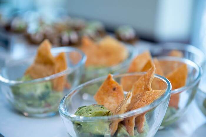 Martini glass of guacamole and homemade tortilla chips.